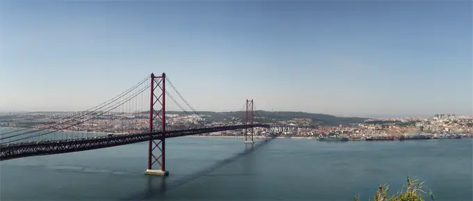 Panorama von Lissabon vor dem Fluss mit der ikonischen roten Hängebrücke